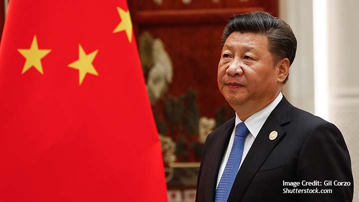 A photo of Xi Jinping standing in front of the Chinese flag.